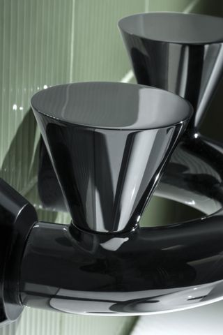 Close-up of black sculptural taps by VitrA and Tom Dixon