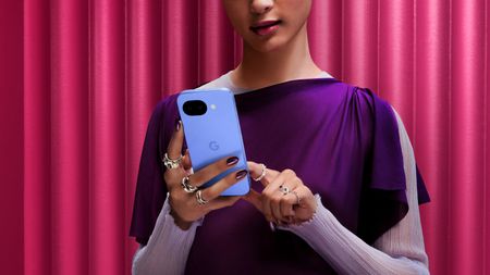 A woman holding the Google Pixel 10a.