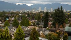 Suburban houses are seen with downtown Vancouver in the distance. 