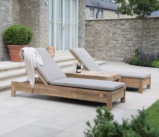 pair of wooden sun loungers on a patio