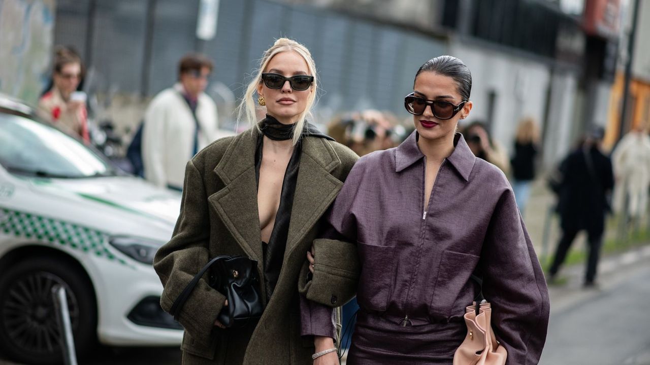 women in green and purple coats on the street with sunglasses