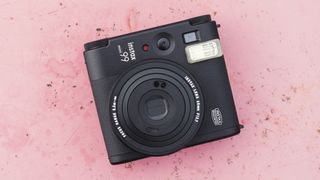 Instax Mini 99 de Fujifilm sur une surface rose marbrée