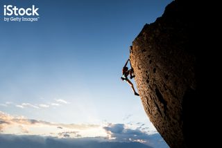 Rock climber on sheer cliff