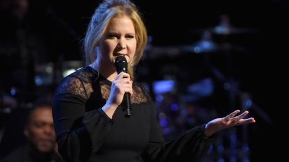 Comedian Amy Schumer speaking into a microphone