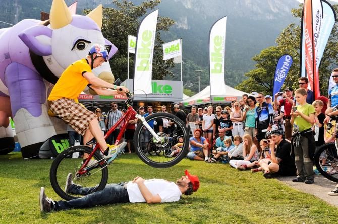A dirt jumper does trials in the company of a brave volunteer