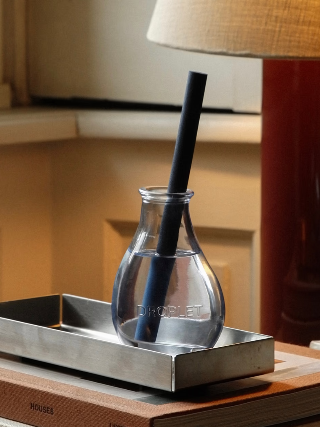 A blue glass reed diffuser with a single blue reed from Droplet