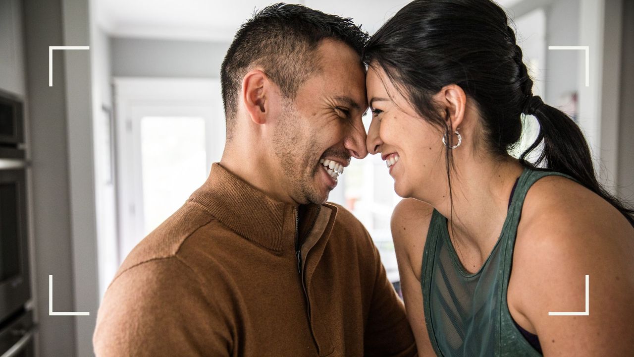 Man and woman smiling and kissing, illustrating the clasp sex position