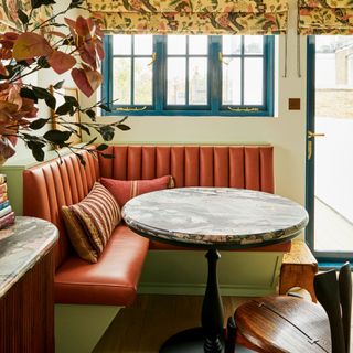 Green kitchen with leather upholstered corner banquette