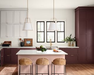 kitchen with dark red cabinets, white walls and pink kitchen island