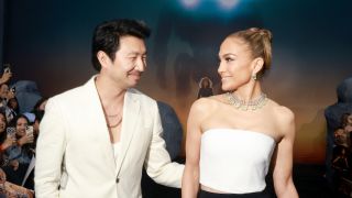 Simu Liu and Jennifer Lopez smiling at each other on the Atlas red carpet