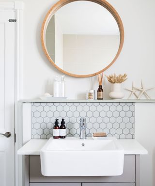 Scandi style bathroom with white basin and wooden mirror above