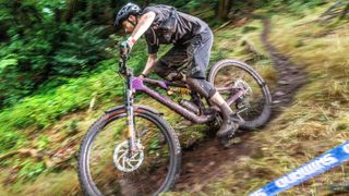 Side view of a rider negotiating muddy mountain bike trails 