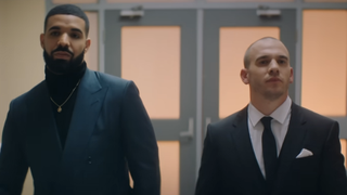 Drake and Shane Kippel walk down the Degrassi hallway in suits to attend their high school reunion in Drake's I'm Upset music video.