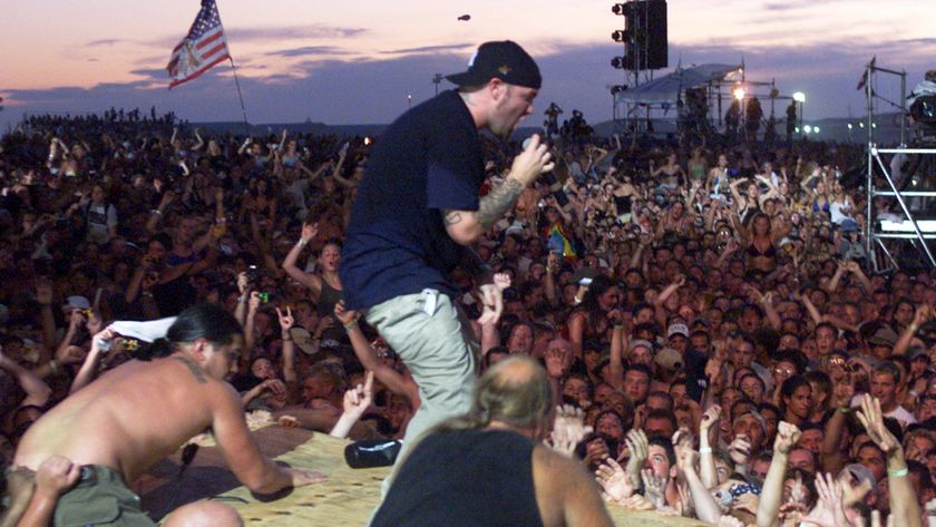 Fred Durst standing on a piece of wood in the crowd at Woodstock 99