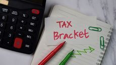 tax bracket written on notebook next to calculator for 2023 tax brackets