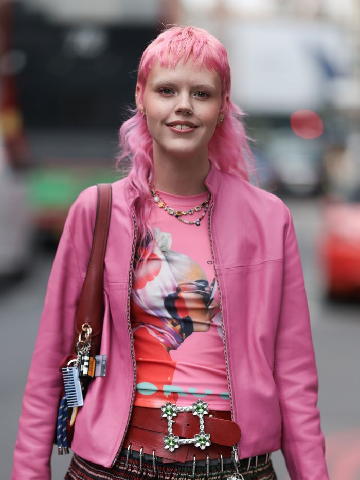 A woman at London Fashion Week with pink hair and a wispy micro fringe