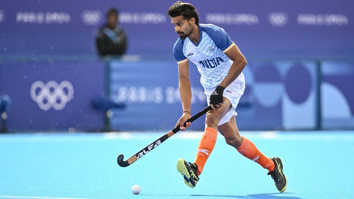 Abhishek Abhishek, in a sky blue shirt and shorts and orange socks, controls the ball for the India men&#039;s hockey team at the 2024 Paris Olympic Games. 