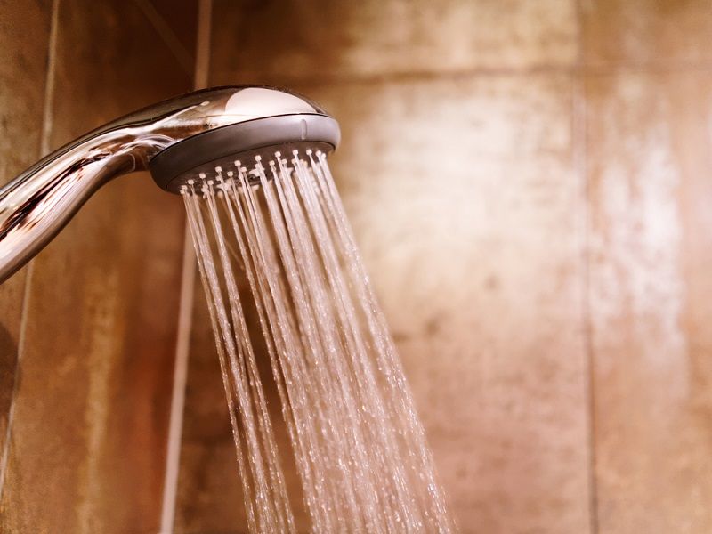 A shower head with running water.