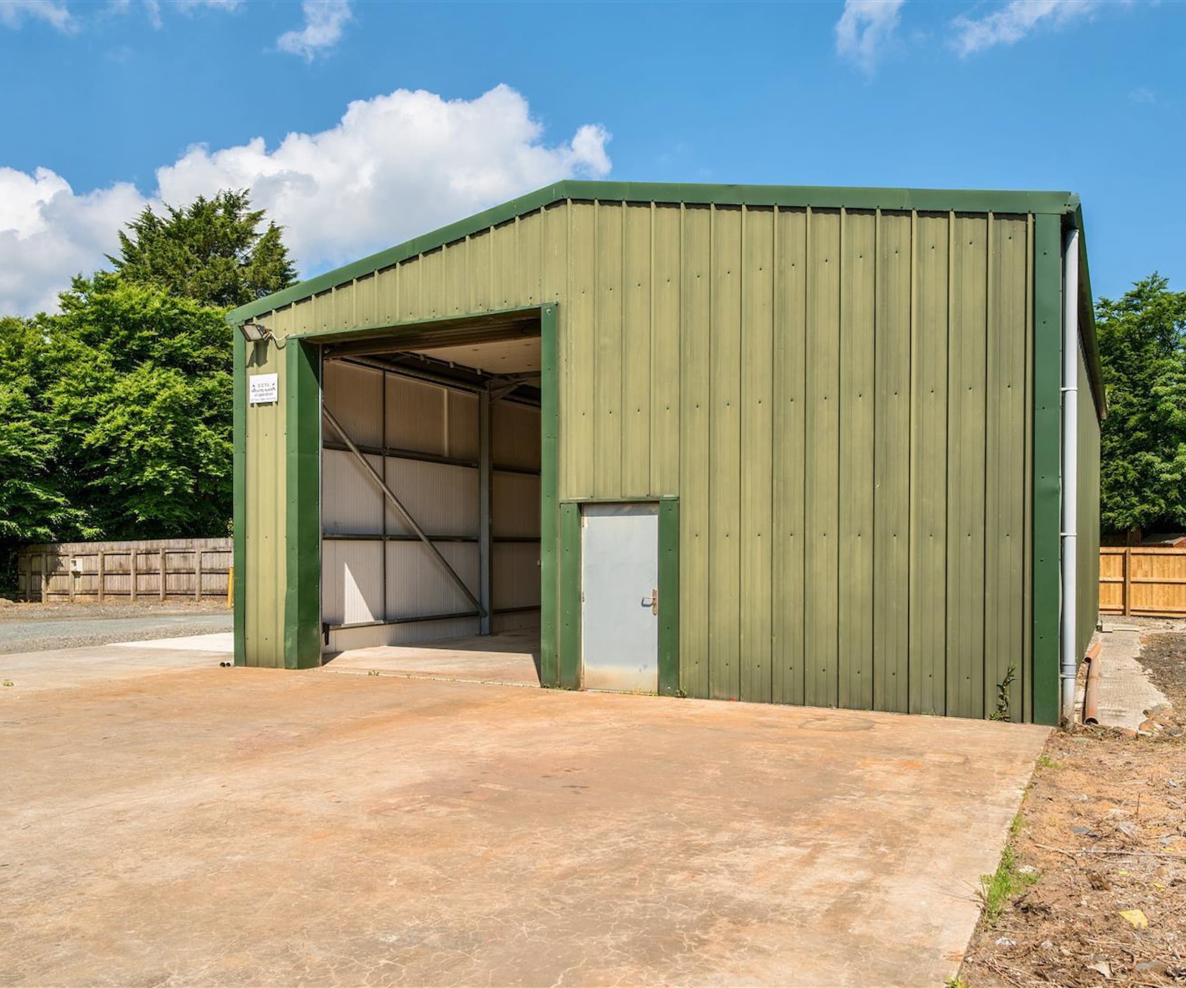 An olive green barn with drive