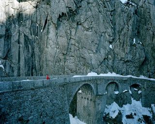 Dror For Tumi Switzerland - woman in red dress pulling luggage on bridge in Switzerland