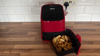 The Instant Vortex Mini with a basket full of fries that were cooked in the appliance