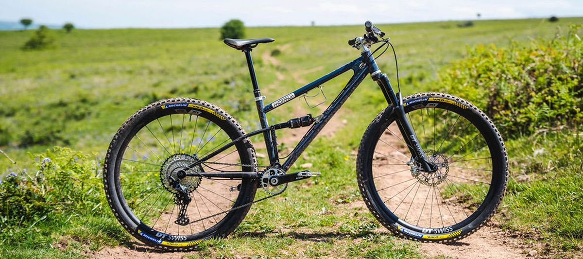 Side view of the Starling Mini Murmur MTB on a grassy hillside