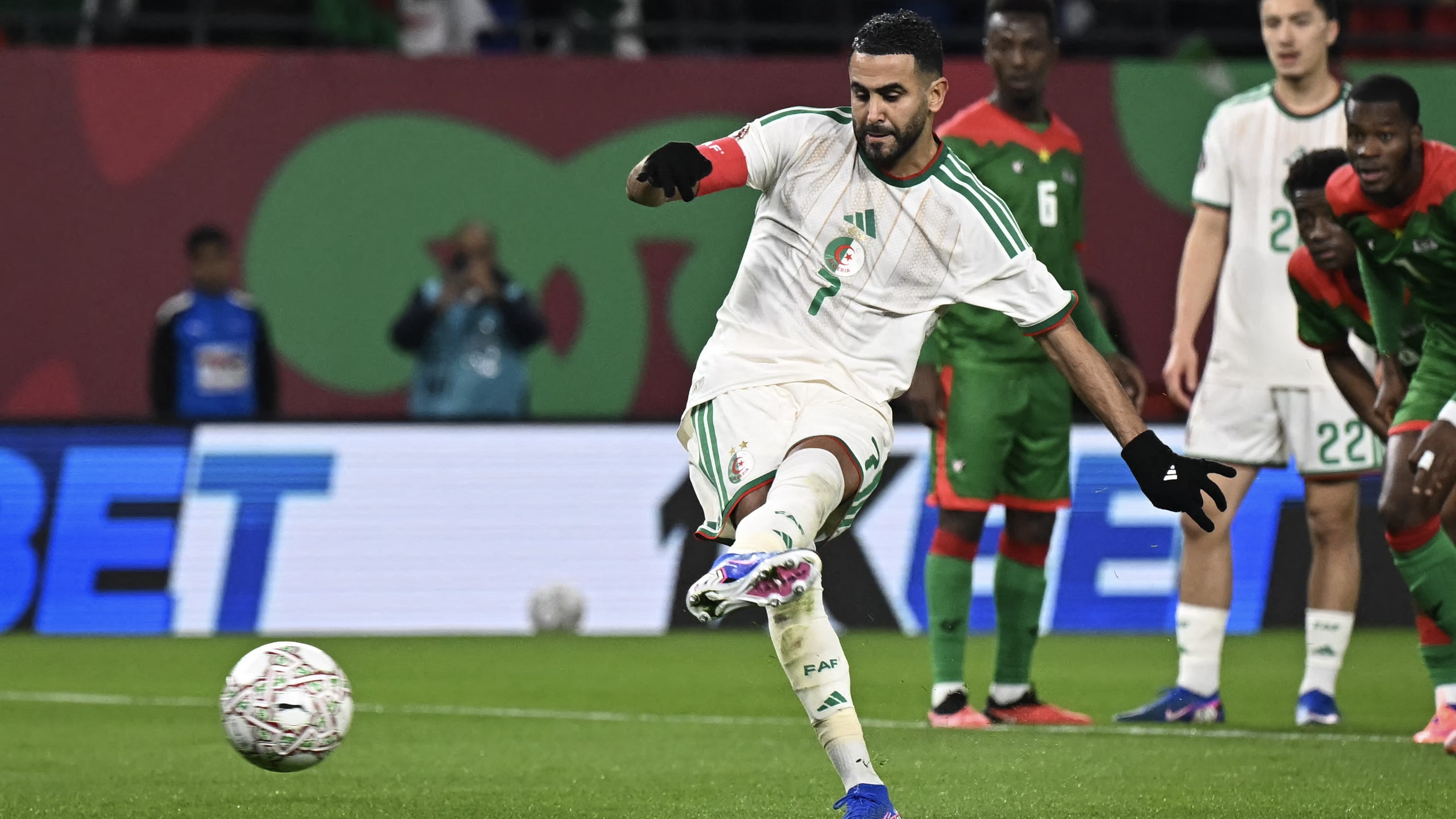 Riyad Mahrez (L) shoots and scores his team's first goal from the penalty spot during the Africa Cup of Nations (CAN) Group E football match between Algeria and Burkino Faso at Moulay Hassan Stadium in Rabat on December 28, 2025. 