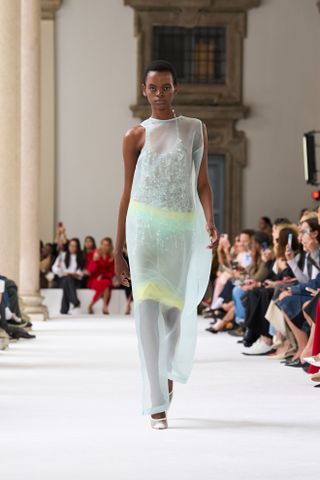 Woman in mint green sheer dress on the SS25 rumway