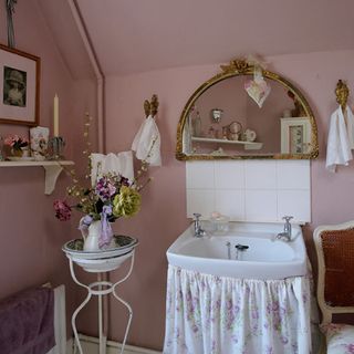 bathroom with pink wall wash basin mirror and flower pot stand