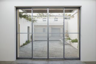 Glass and metal doors leading into the back courtyard of Emeco House