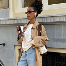 @amaka.hamelijnck wearing a trench coat, denim Bermuda shorts, and knee-high boots.