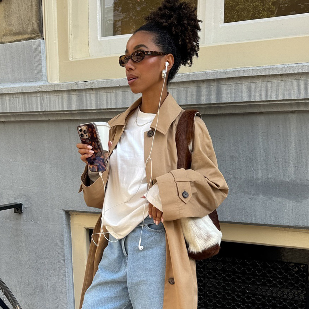 @amaka.hamelijnck wearing a trench coat, denim Bermuda shorts, and knee-high boots.