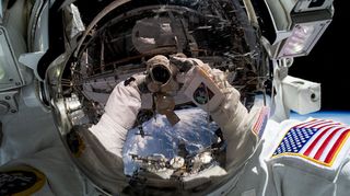 seflie snapped by nasa astronaut woody hoburg during a spacewalk showing his helmet, the visor of which reflects an image of earth against the blackness of space