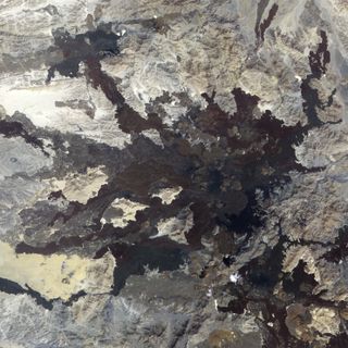 In northwestern Saudi Arabia, east of the Red Sea port city of Umm Lajj, lies a field of volcanic lava known as Harratt Lunayyir. The Advanced Spaceborne Thermal Emission and Reflection Radiometer (ASTER) on NASA’s Terra satellite captured this false-colo