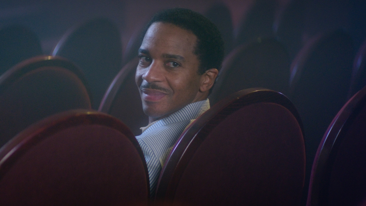 Andre Holland sitting in a row of seats in The Actor