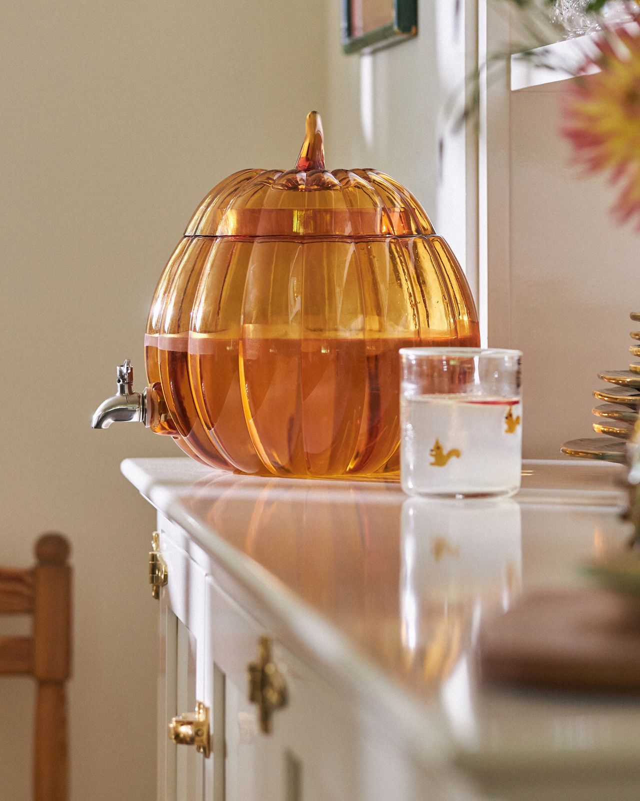 A kitchen with pumpkin-shaped mugs, a water jug and plates
