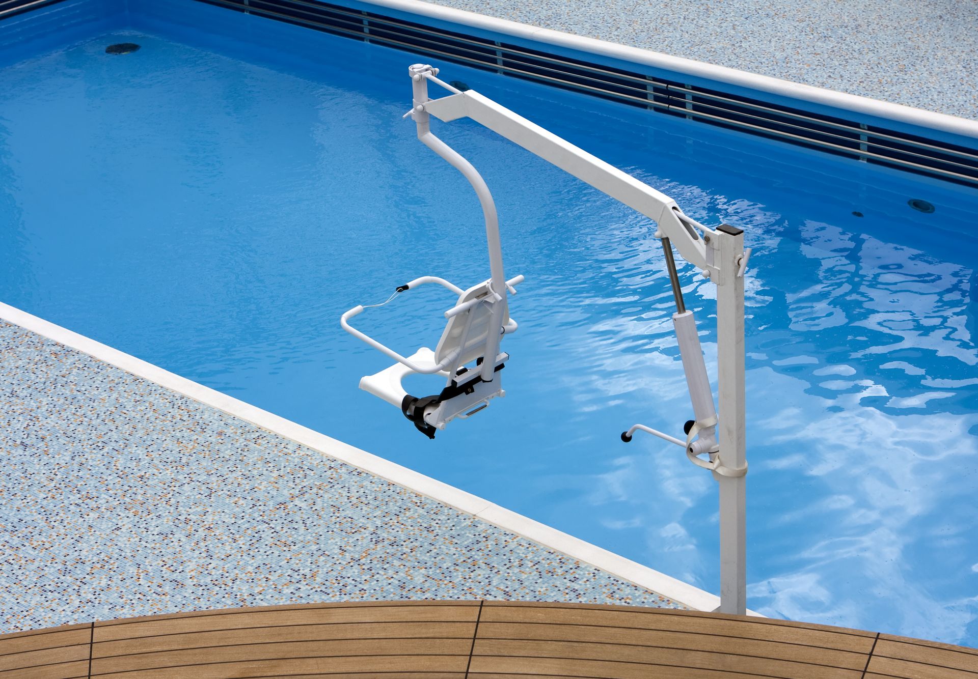 Pool hoist at a swimming pool, used as a mobility aid for persons with disabilities.