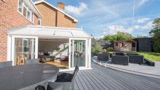 Conservatory exterior and spacious garden with shed and outdoor furniture
