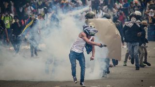 Protest in Caracas, Venezuela against the government of Nicolas Maduro. Protester launches tear gas that was fired by the national guard