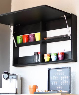 An upcycled black pop-up folding desk with colorful cups