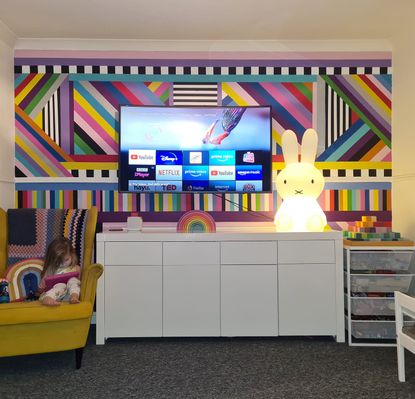 a brightly coloured living room wall painted using samples and masking tape