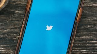 Twitterin logo sinisellä puhelinnäytöllä