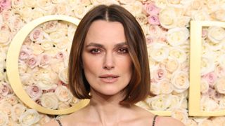 Keira Knightley is pictured with a short, jaw-length bob in front of a floral, rose background at the 82nd Annual Golden Globe Awards at The Beverly Hilton on January 05, 2025 in Beverly Hills, California.