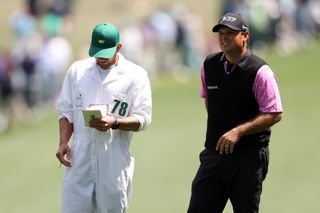 Patrick Reed talks to his caddie during the 2023 Masters