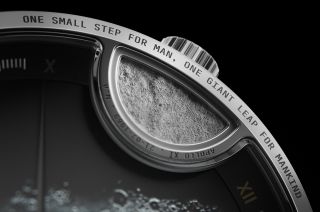 a close-up photo of an analog watch's face, showing the inscripition "one small step for man, one giant leap for mankind."
