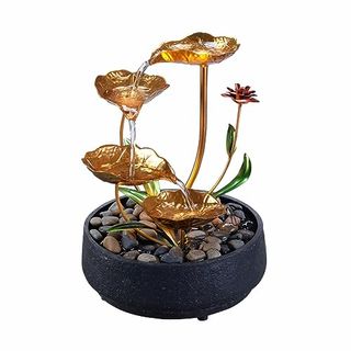 A small plug-in tabletop water fountain. golden lotus leaves at varying heights with water draining down them.