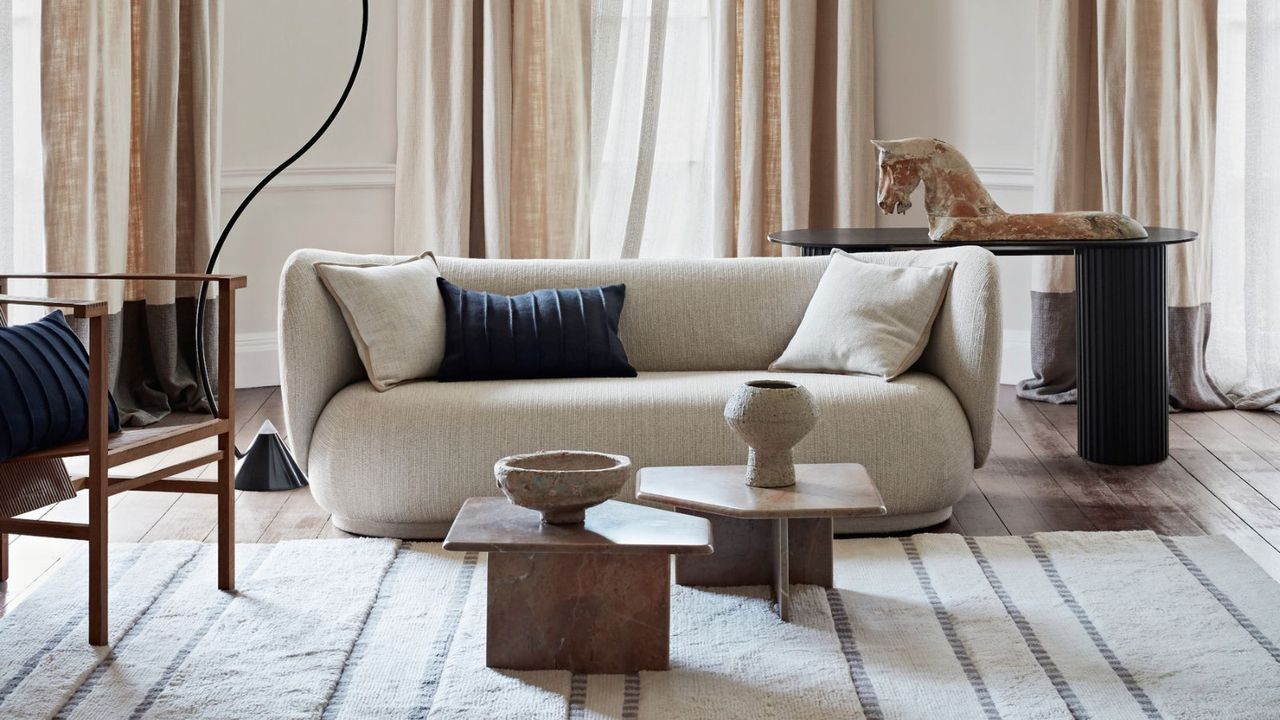 Living room in neutral colors with white sofa, coffee table and linen curtains