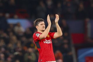 Harry Maguire applauds Manchester United's fans after defeat to Bayern Munich in December 2023.