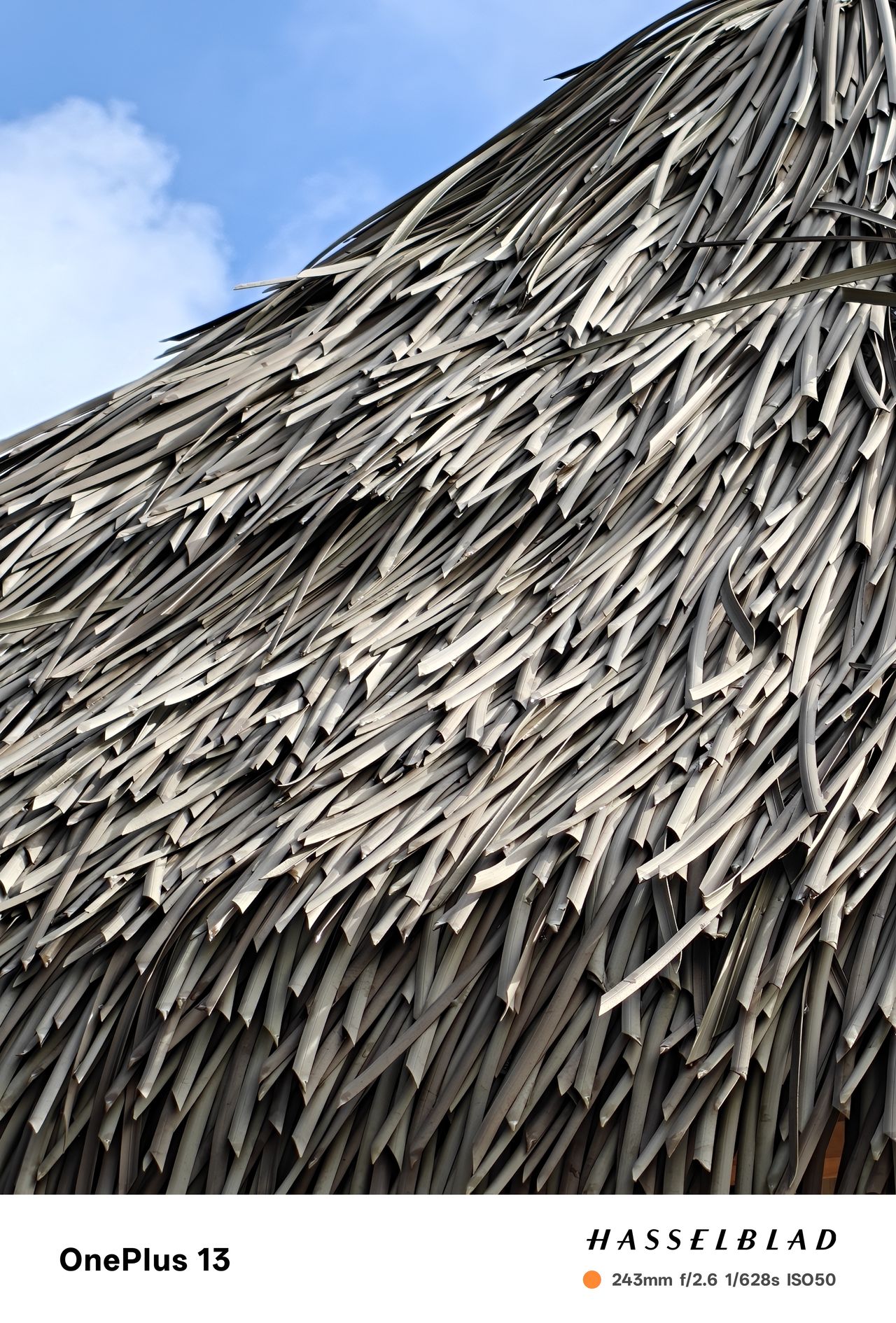 Close-up of a thatched beach canopy with a blue sky in the background
