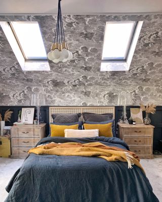 yellow and navy bedding with cloud wallpaper, loft bedroom, matching bedside tables, retro ceiling light